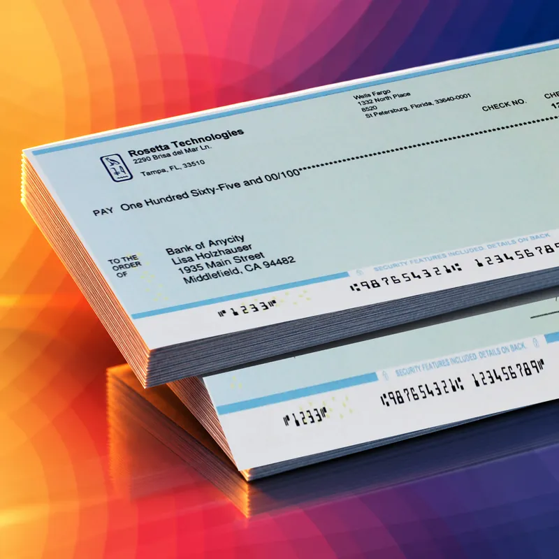 A fanned stack of printed checks with their E-13B MICR lines in view, on Rosetta Technologies' brand art